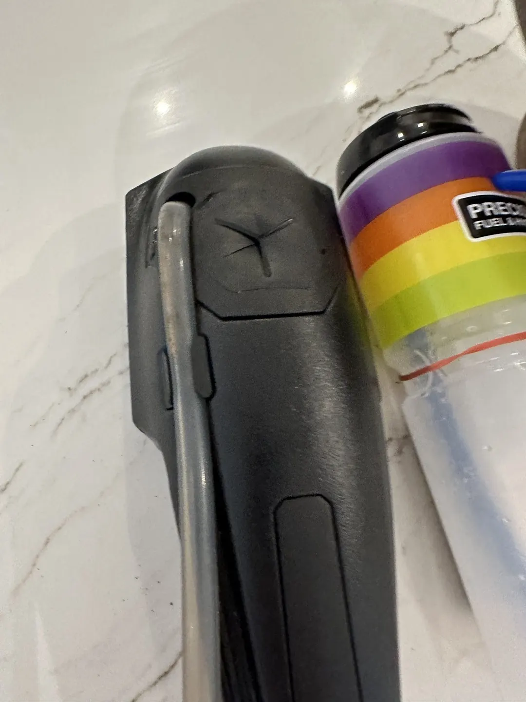 The refill port on the bike's own bottle: a flush rubber pad with a cross-cut slit
